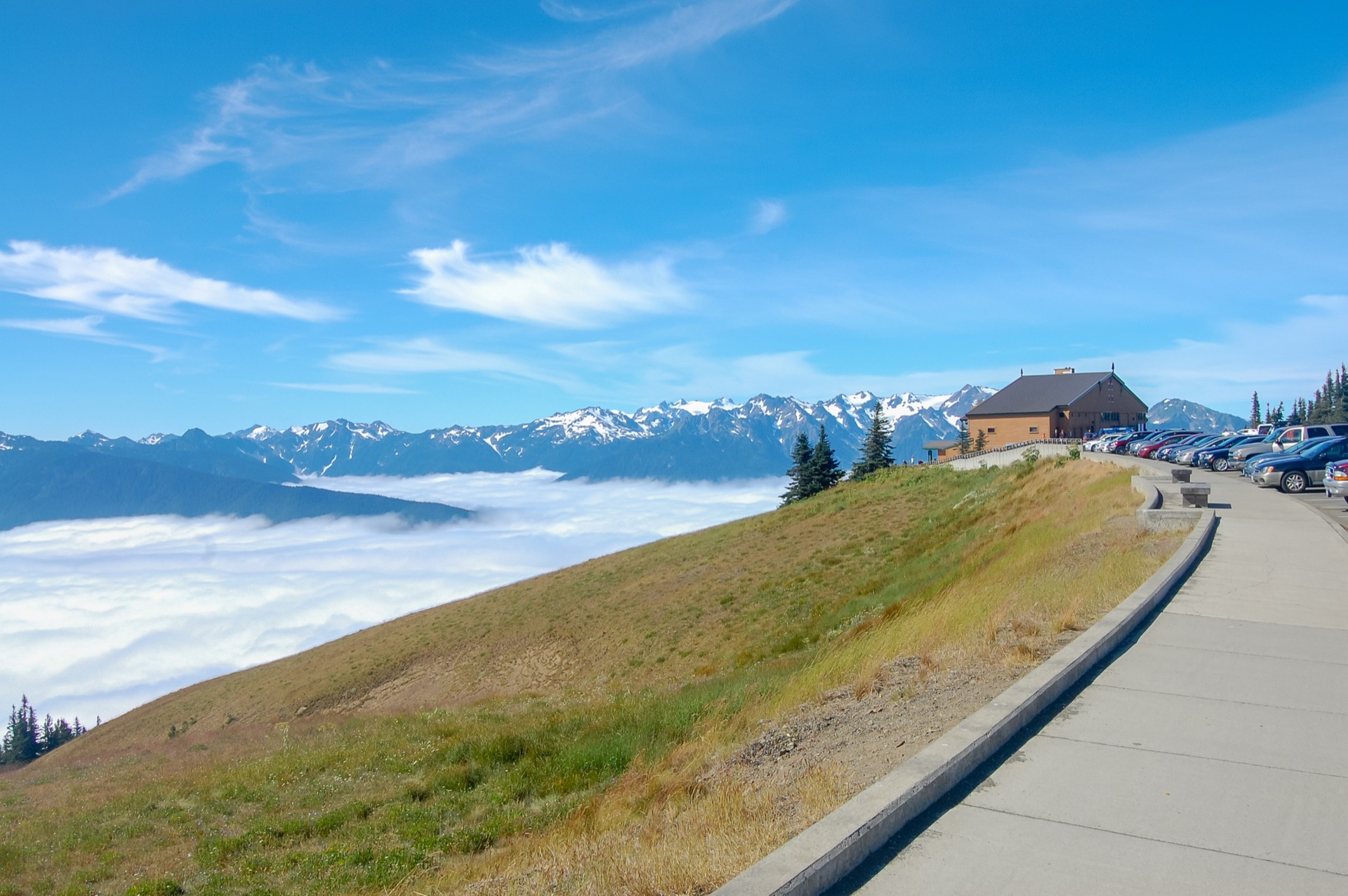 The Hurricane Ridge Visitor Center building at Olympic National Park in Washington, with mountain meadows and the Olympic Range peaks visible behind