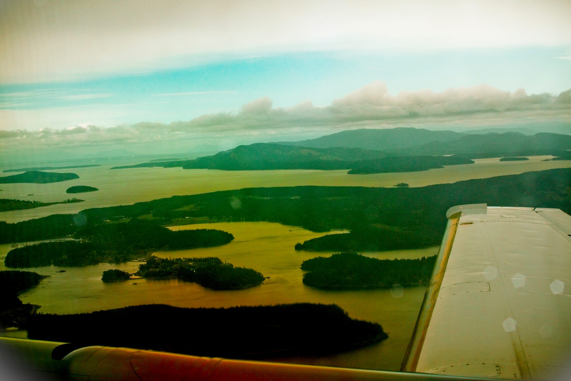 Aerial view of the San Juan Islands archipelago in Washington State, showing forested islands and the blue waters of the Salish Sea