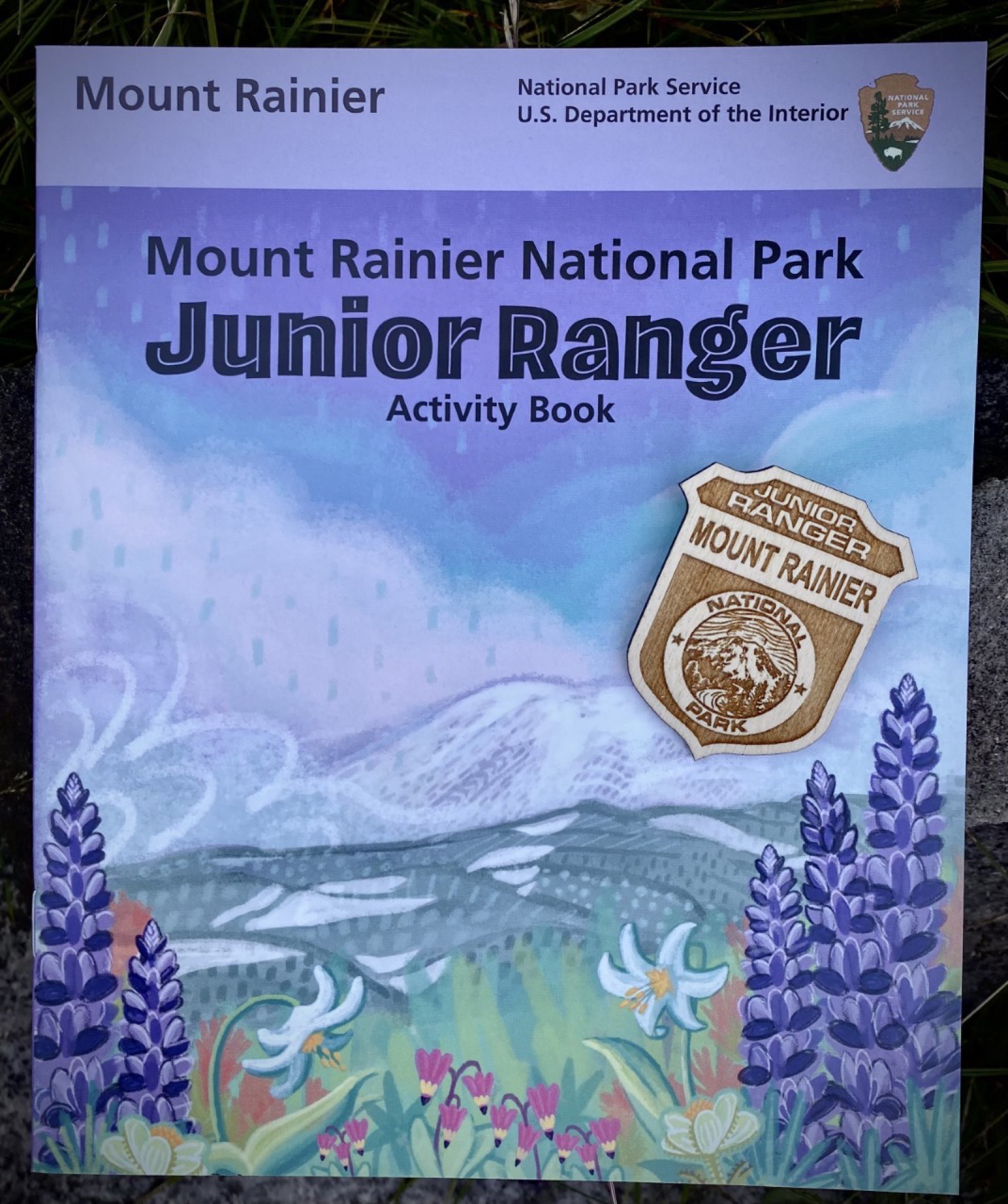 Cover of a booklet with an illustration of a mountain framed with wildflowers.
